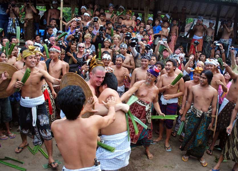 Two men performing perang pandan in a crowd at Tenganan Pegringsingan