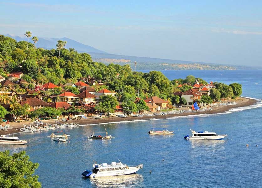 Various boats and buildings along the coast of Amed Beach