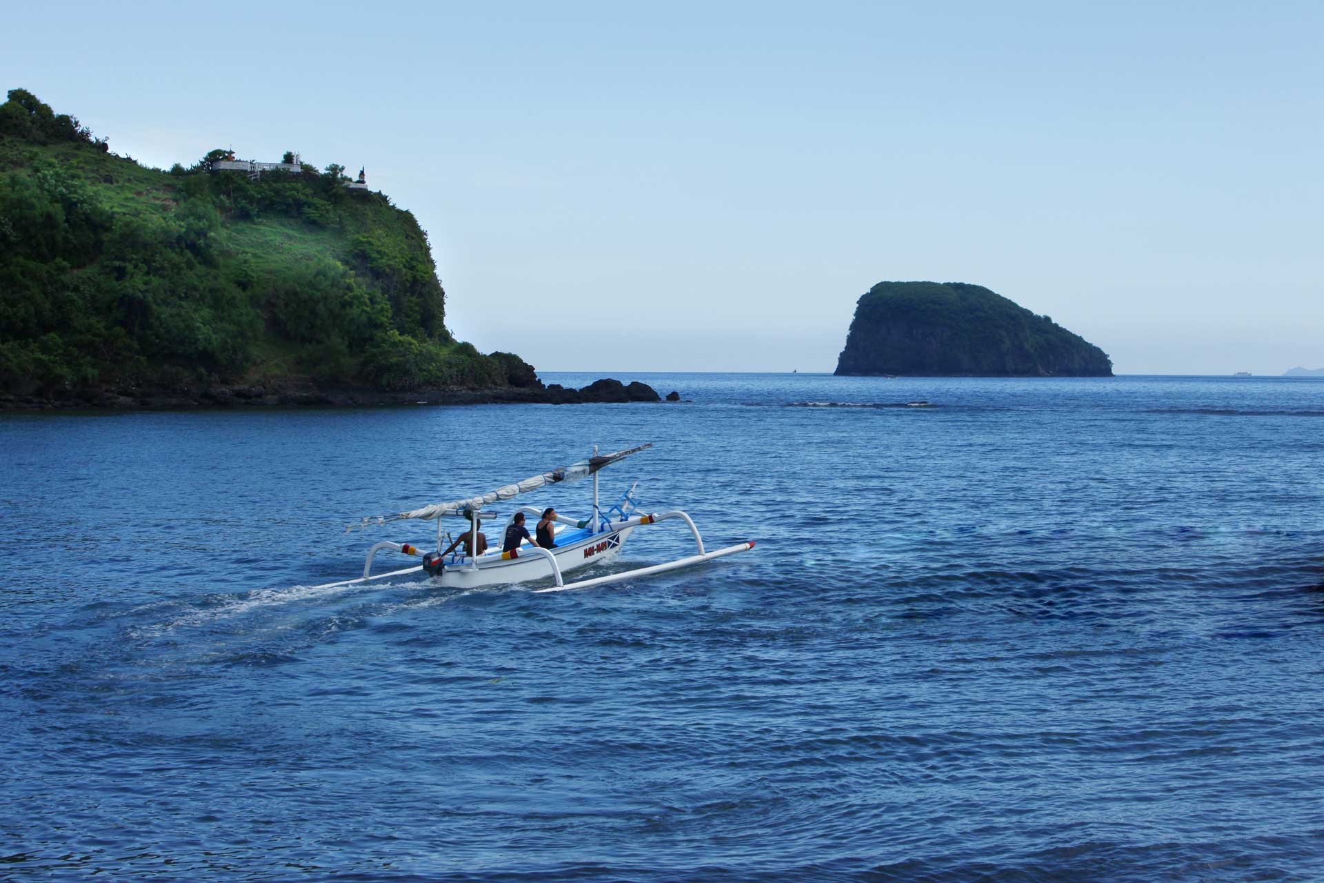 People sailing on a jukung towards Gili Tepekong
