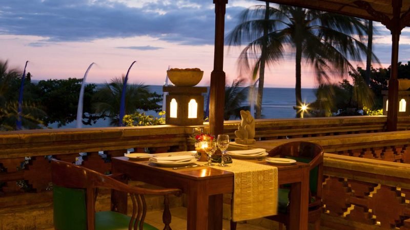 Candlelit dining table with dinnerware during sunset