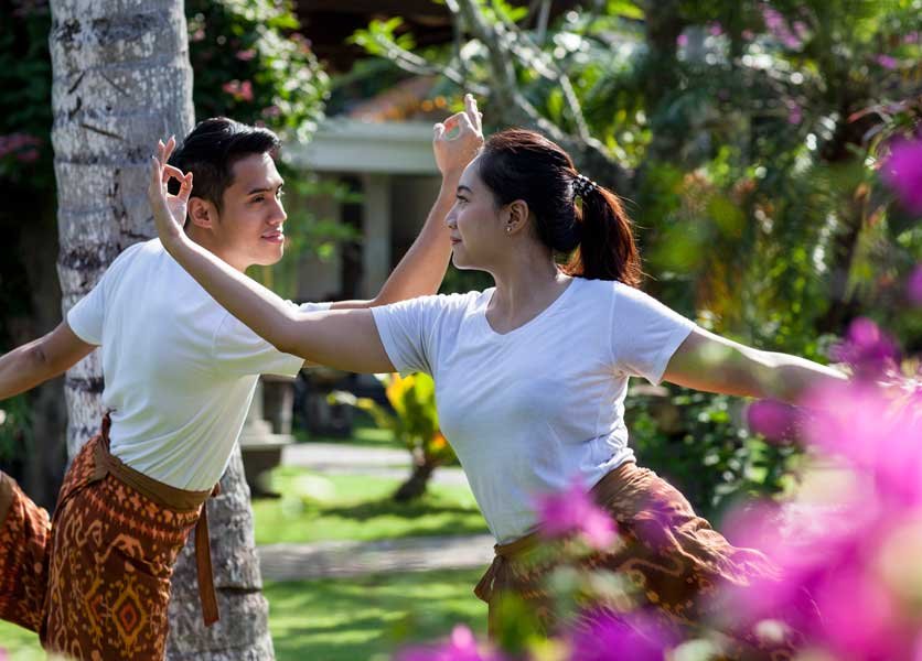 Couple doing a yoga pose at Puri Bagus Candidasa garden