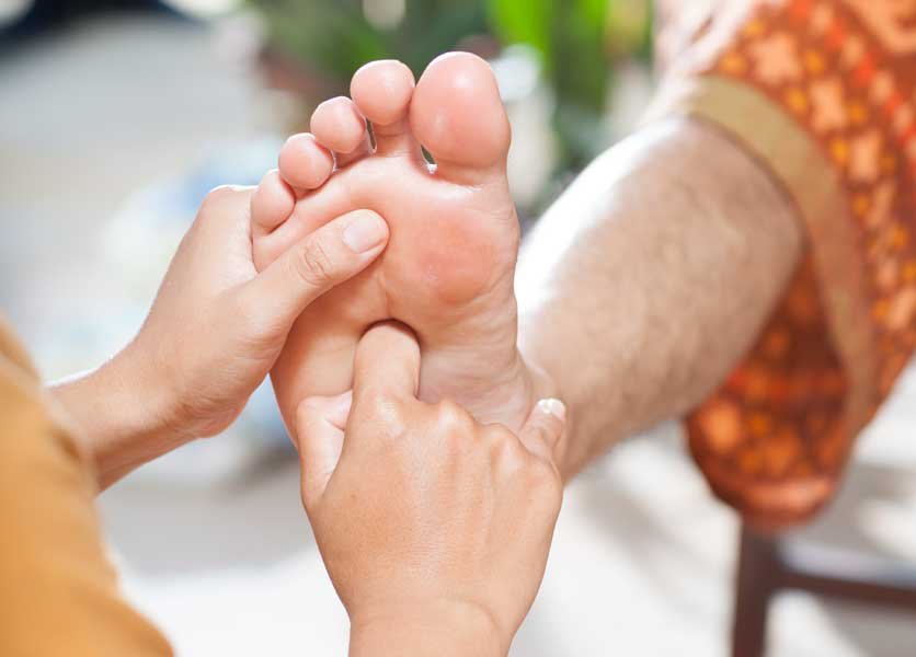 A foot being massaged during foot reflexology